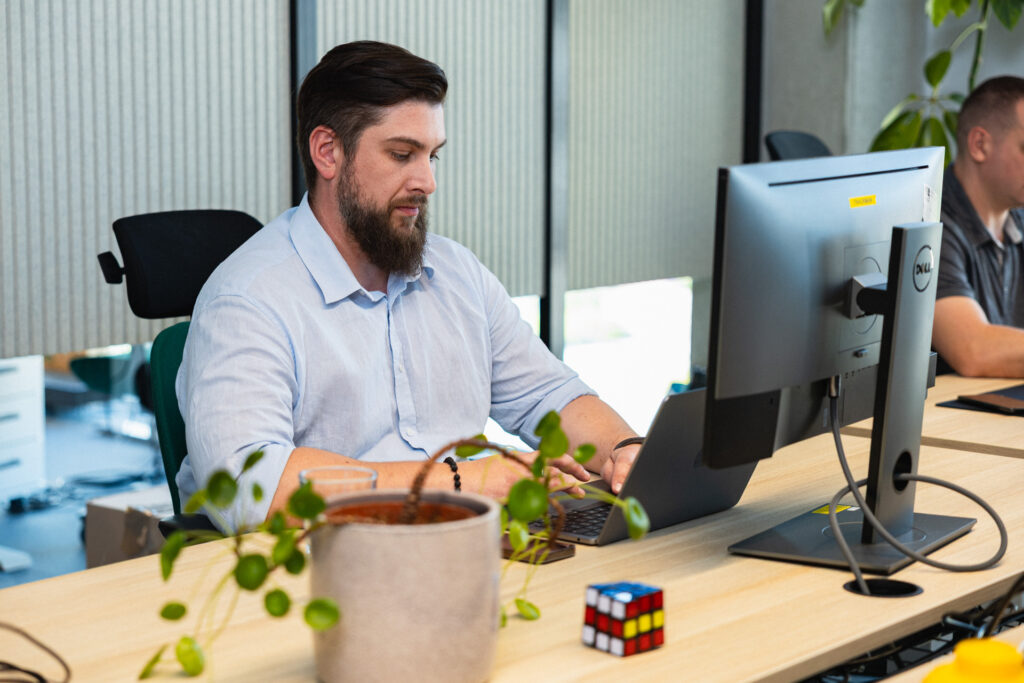 Bartek Mocek from Spyrosoft AdTech in front of a computer