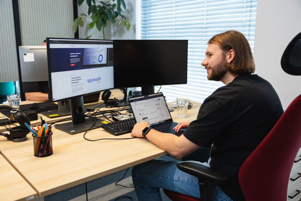 Szymon Małejki from the Spyrosoft AdTech team in front of a computer