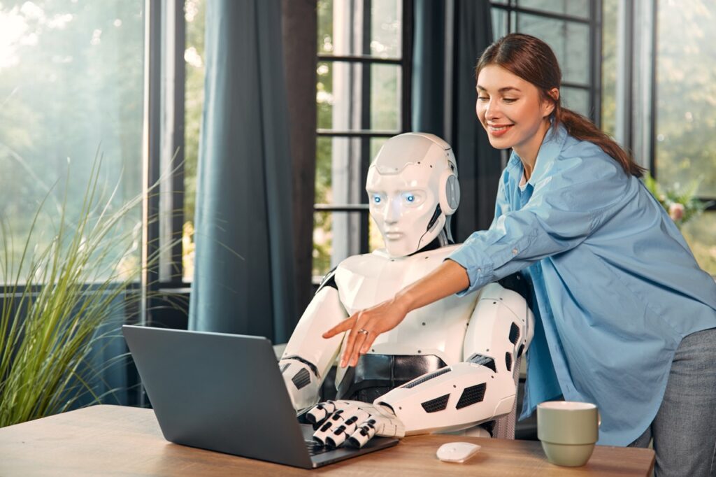 A woman and robot in front of a computer.