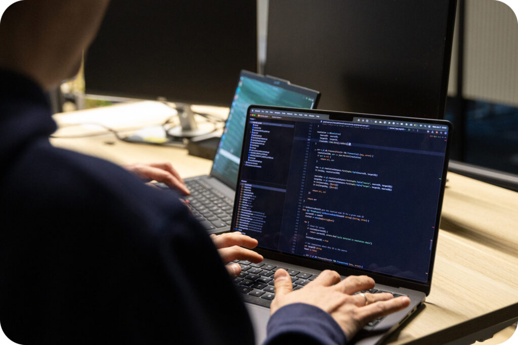 A photo of a Spyrosoft AdTech employee coding on a laptop.