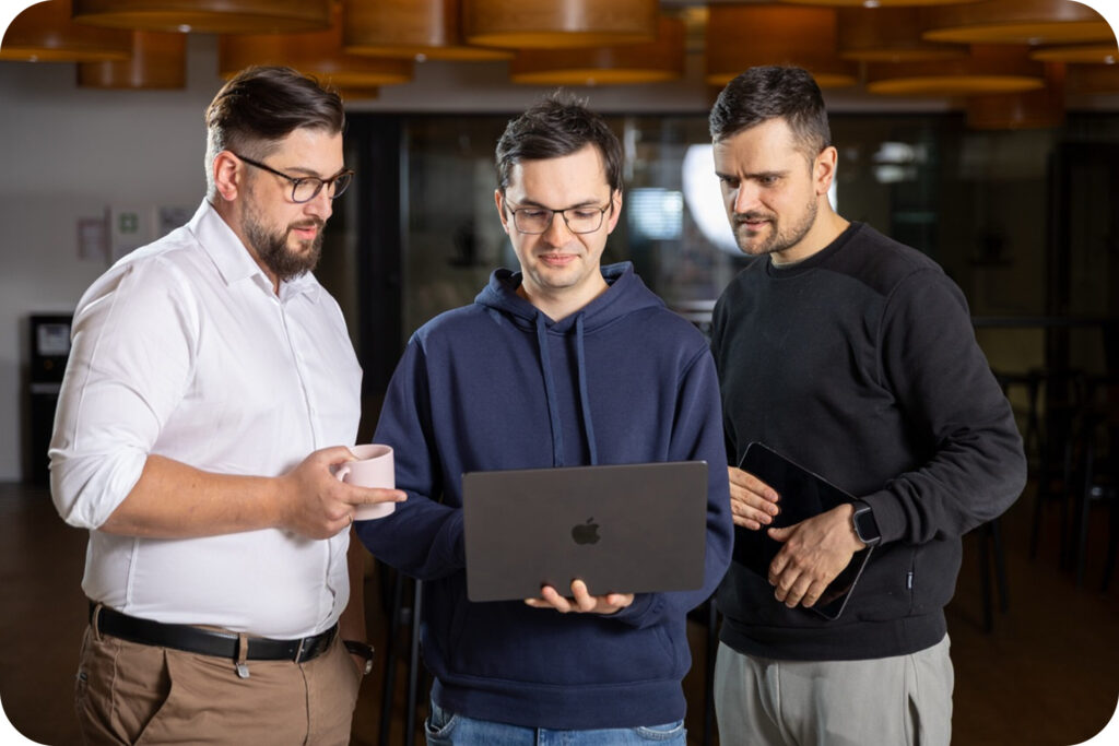 An image of Spyrosoft AdTech employees looking at a laptop