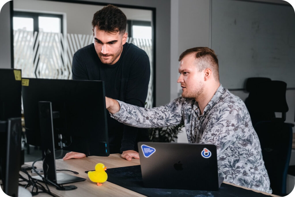 2 Spyrosoft employees in front of a computer