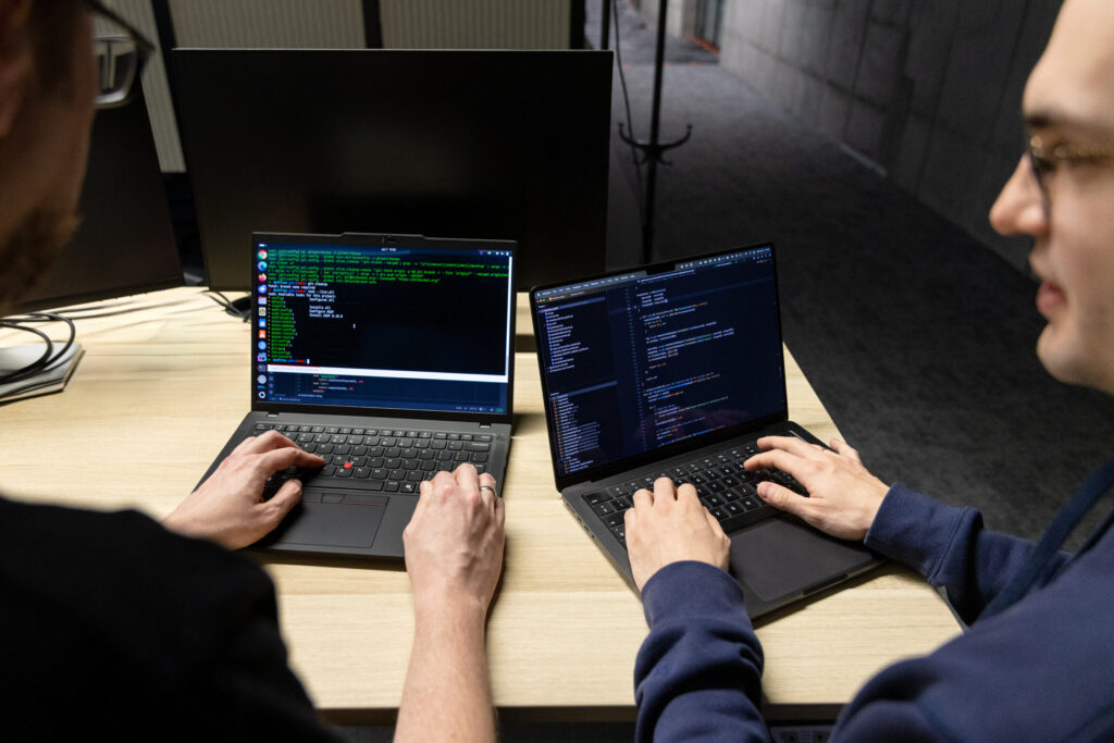 Two Spyrosoft AdTech employees working on laptops.