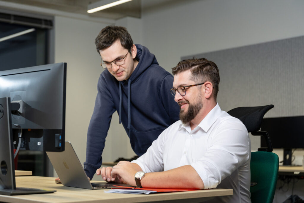 Two Spyrosoft AdTech employees looking at a laptop.